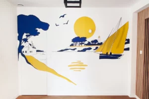 Fresque murale à Laillé représentant un paysage breton bleu et jaune, création sur mesure signée Atelier Lunaïa.